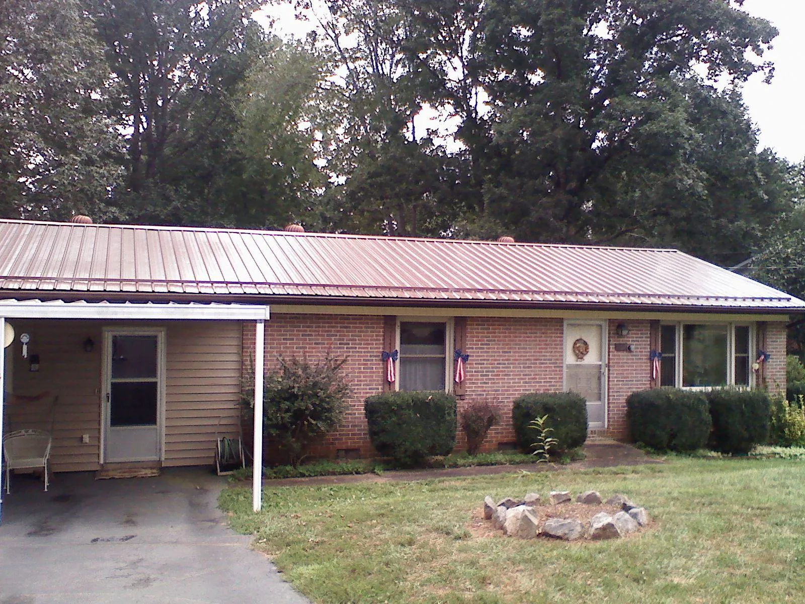 Bronze metal roof and carport on a brick ranch home — Roof Repair work by our crew in Plainview